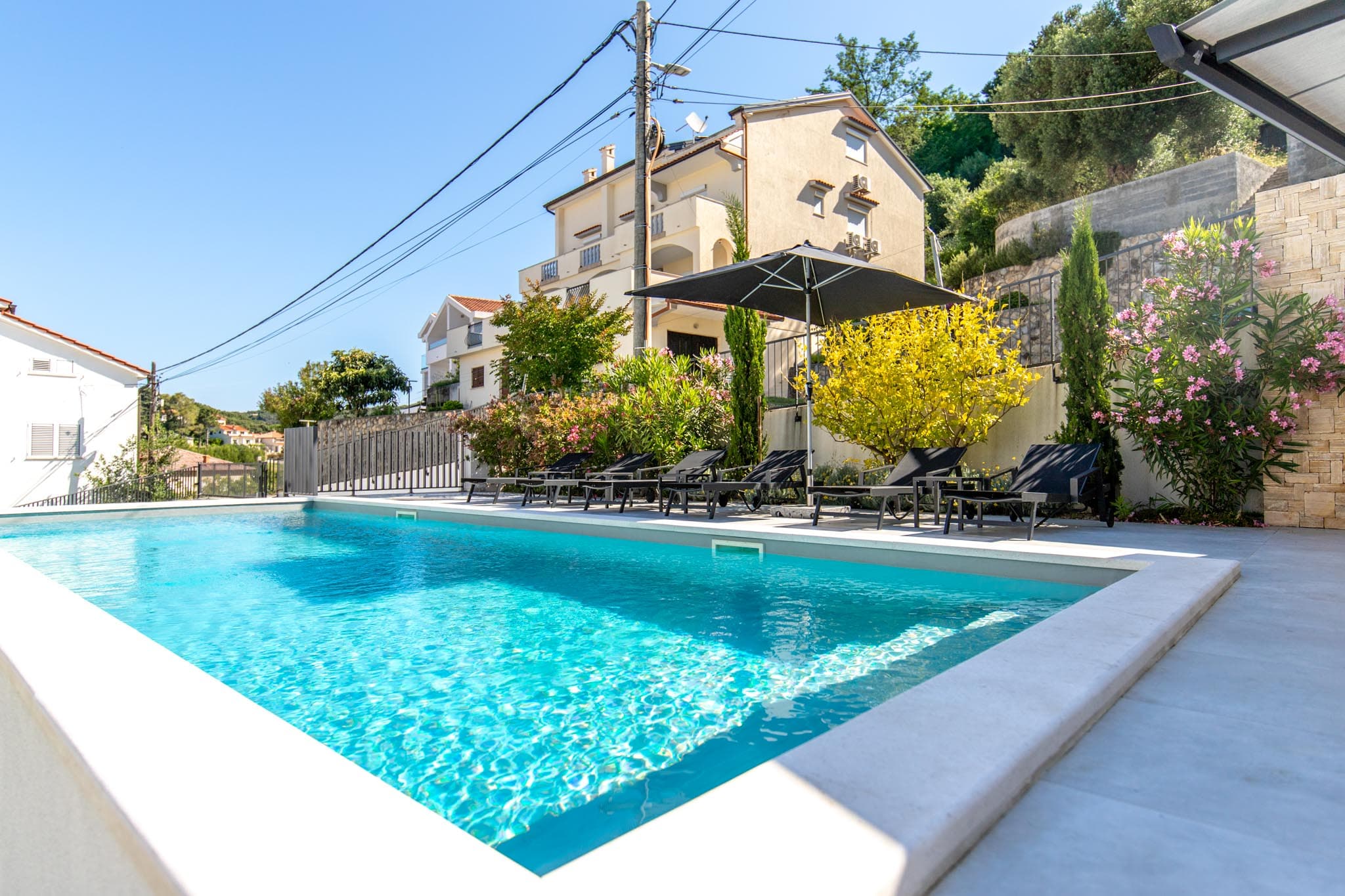 Villa Veronica — Pool mit Sonnenschirm und Liegen