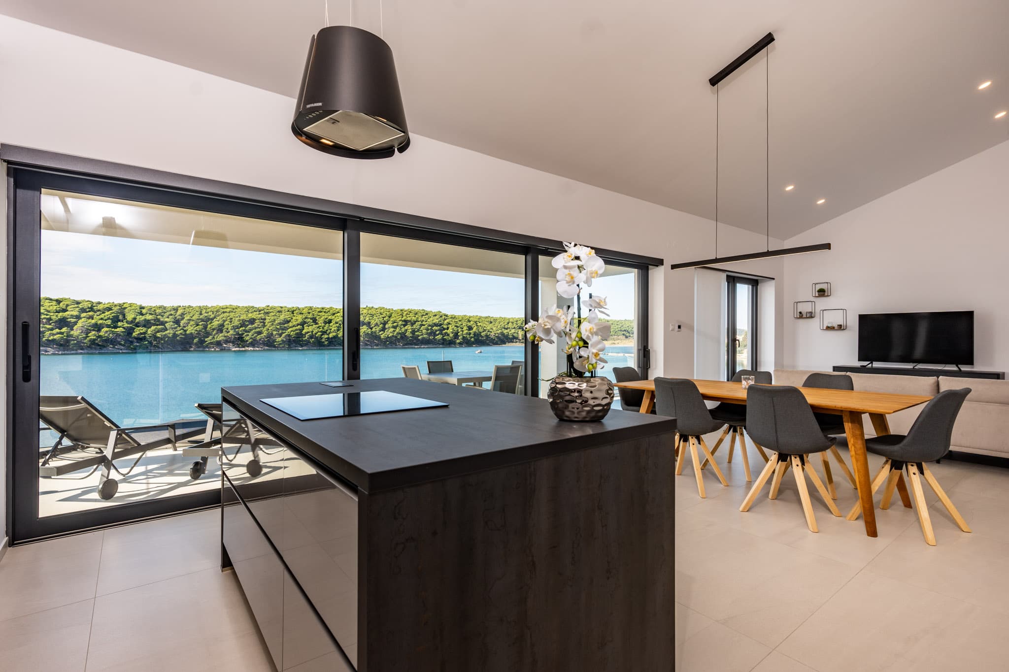 Küche und Essbereich des Penthouse Apartments mit Blick über den Balkon auf die Bucht